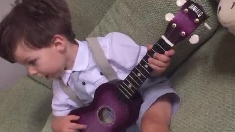 Cute baby playing ukulele
