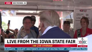 Brian Glenn receives a pork chop from President Donald J Trump at the Iowa State Fair