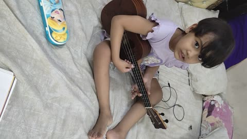 Small kid playing ukelele