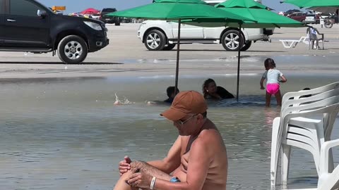 Man Shaves Legs On Beach