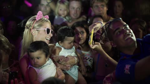 Paris Hilton holds twin babies at charity event