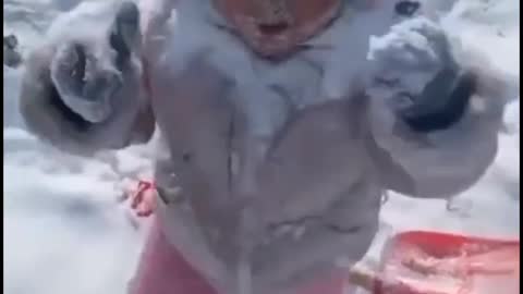Cute baby playing with snow.