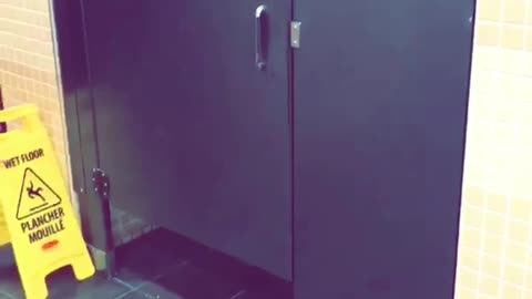 Girl tries to flip over bathroom stall and kicks ceiling