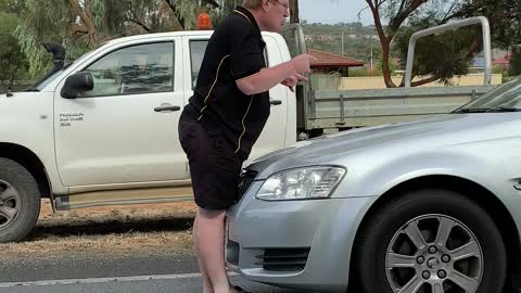 Perturbed Person Climbs onto Moving Car