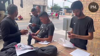 Brownsville, TX: Migrants open their DHS packets and use their government issued cell phones