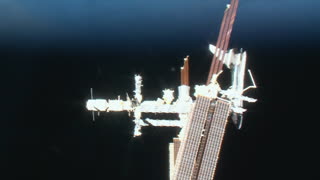 The Space Shuttle docked to the ISS with the planet Earth in the background