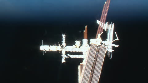 The Space Shuttle docked to the ISS with the planet Earth in the background