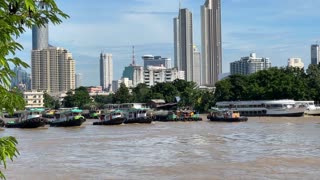5 tugboats pulling huge barge at Chao Phraya river in Bangkok Thailand