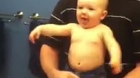 Baby adorably flexes muscles with dad