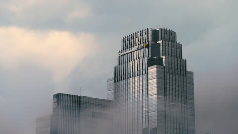 Low Angle Shot of Clouds Passing Past a Skyscraper 01