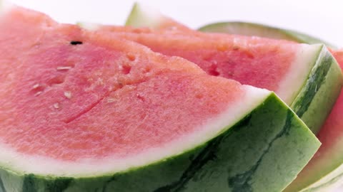 Rich watermelon cut into slices on a white background