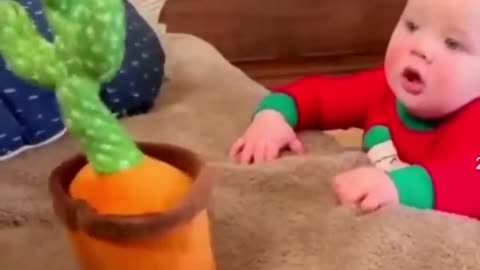 Cute baby playing with dancing cactus