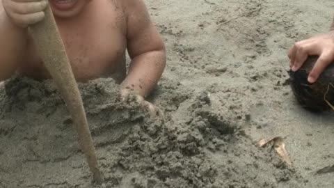 my son 2 years old playing at the beach