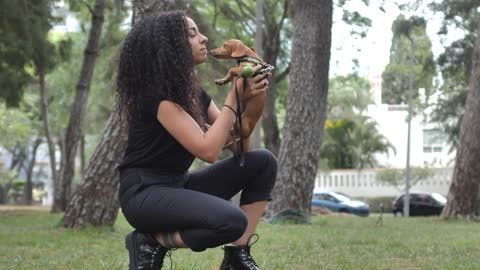 Girl kissing her little dog in a park