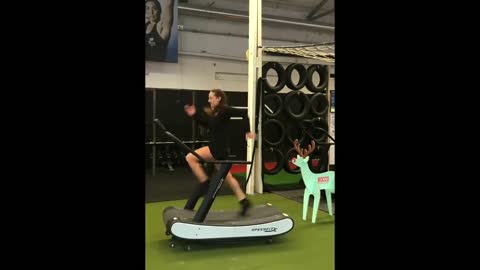 Woman runs full speed on treadmill wearing fine dress, heels