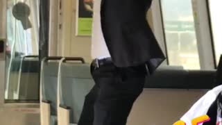 Guy in suit does pull ups on train