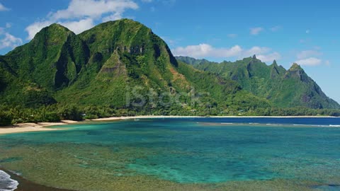 Cinematic aerial view of dramatic mountains and beautiful ocean on North Shore of Kauai