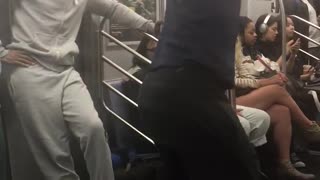 Guy dark blue shirt dancing on pole music subway