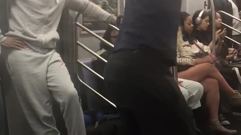 Guy dark blue shirt dancing on pole music subway