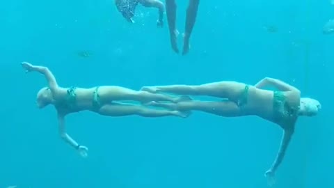 3 swimmers who dive to the bottom of the sea to create a super beautiful shape