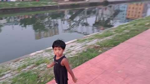 a little girl playing beside the water