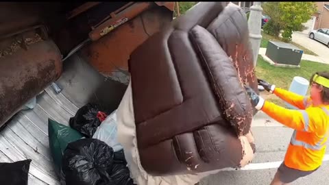 Garbage truck eating couch