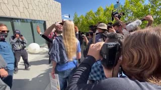 Protesters destroy a man's "We like Dave" sign at the Netflix walkout