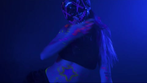 Young woman dancing with a mask under a party light