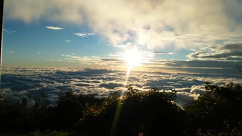 ENJOYING THE SUN RISING FROM THE TOP OF THE MOUNTAIN