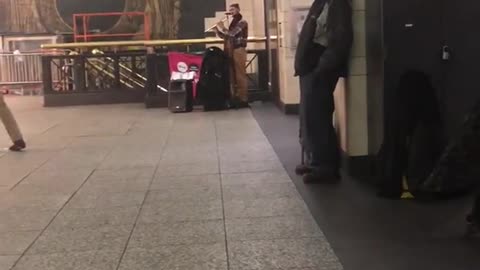 Couple and old man dance to flute dance music in subway station