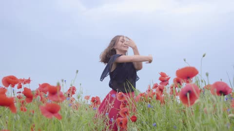 Girl dancing happily in the middle of a field of pink