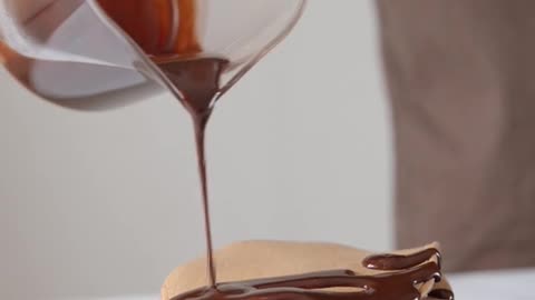 Pouring Chocolate Syrup on Top of Pancakes