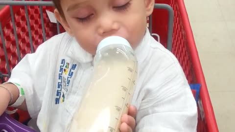 Baby can't decide between sleeping and his bottle