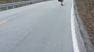 Downhill skateboard slides on butt