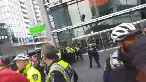 A large crowd gathered in Vancouver, ahead of Bill Gates' Ted Talk, shouting "Arrest Bill Gates!"