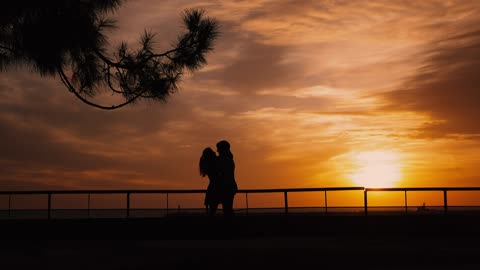 Lovers holding each other on a romantic sunset