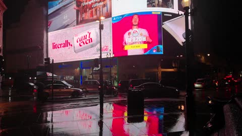 Street with rain at night and pedestrians sheltering from rain