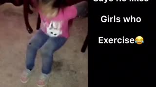 Pink shirt little girl exercises on carpet