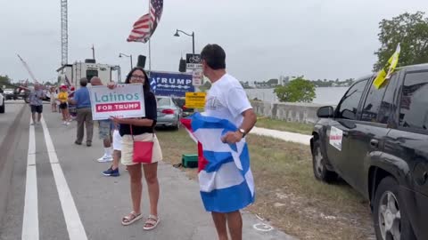 Woman holds “Latinos for Trump” sign outside Mar-A-Lago following FBI raid