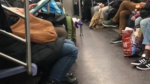 Man makes balloon animal hearts on subway train, gives one to woman recording