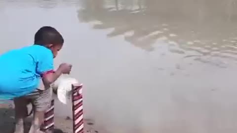 Anak kecil ini beruntung sekali dapat ikan besar di sungai