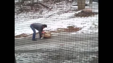 Man struggles to take groceries up icy hill