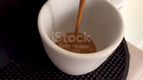 Coffee falling into the white ceramic cup