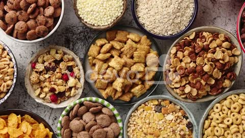 Assortment of different kinds cereals placed in ceramic bowls on table