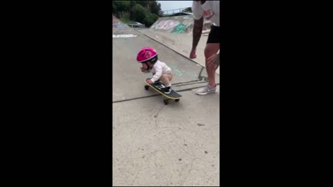 Young Girls Showcases Skateboard Skill with Dad's Help