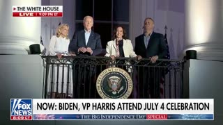 Biden grabs Kamala's hand and holds it up as they watch the fireworks