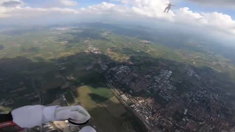 Man Skydiving Through The Clouds While Sit Posing