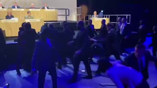 Climate activists in London attempt to storm the stage during a Shell shareholders meeting