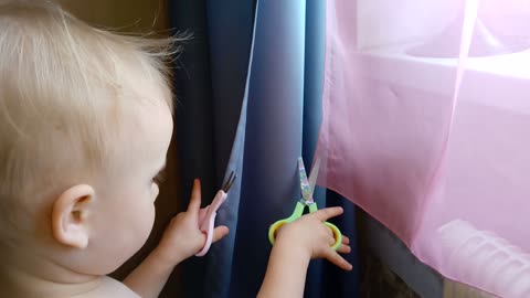 Funny baby decided to cut the curtains