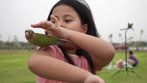 A Girl Holding A Parrot